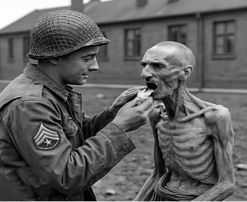 Il soldato che condivise la sua razione con uno scheletro – Nordhausen, Germania, 1945  Alle porte del campo di concentramento di Nordhausen, il soldato americano Lee Davis si fermò di colpo. Rannicchiato contro un muro giaceva un uomo così emaciato da sembrare più un'ombra che un essere umano: uno scheletro che respirava e non riusciva nemmeno a sollevare la testa. I suoi occhi si aprirono, un batter d'occhio, come se evocasse l'ultima scintilla di vita.  Davis si inginocchiò accanto a lui, frugò nello zaino e staccò un pezzo della sua razione di cioccolato. Con una cura che sembrava quasi sacra, glielo premette in bocca. L'uomo iniziò a piangere – lacrime silenziose e tremanti – stringendo quel pezzetto di cioccolato come se fosse un tesoro. Non riusciva a masticare, non ancora, ma lo teneva stretto come una promessa.  